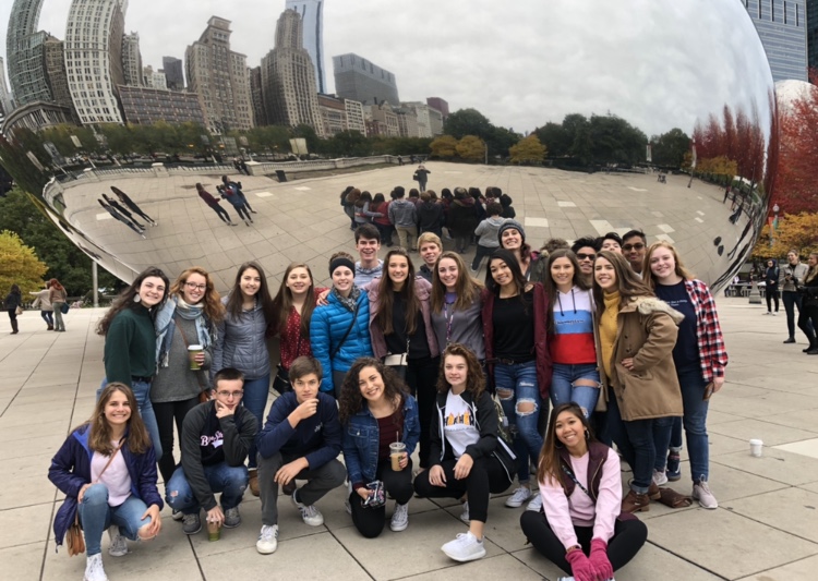 A large group of tourists standing in front of the Cloud Gate