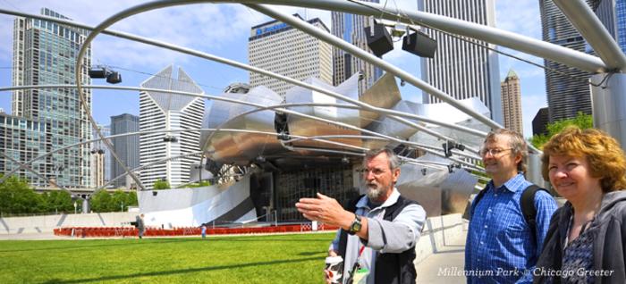 a guide showing a couple around the park in front of the jay Pritzker Pavilion